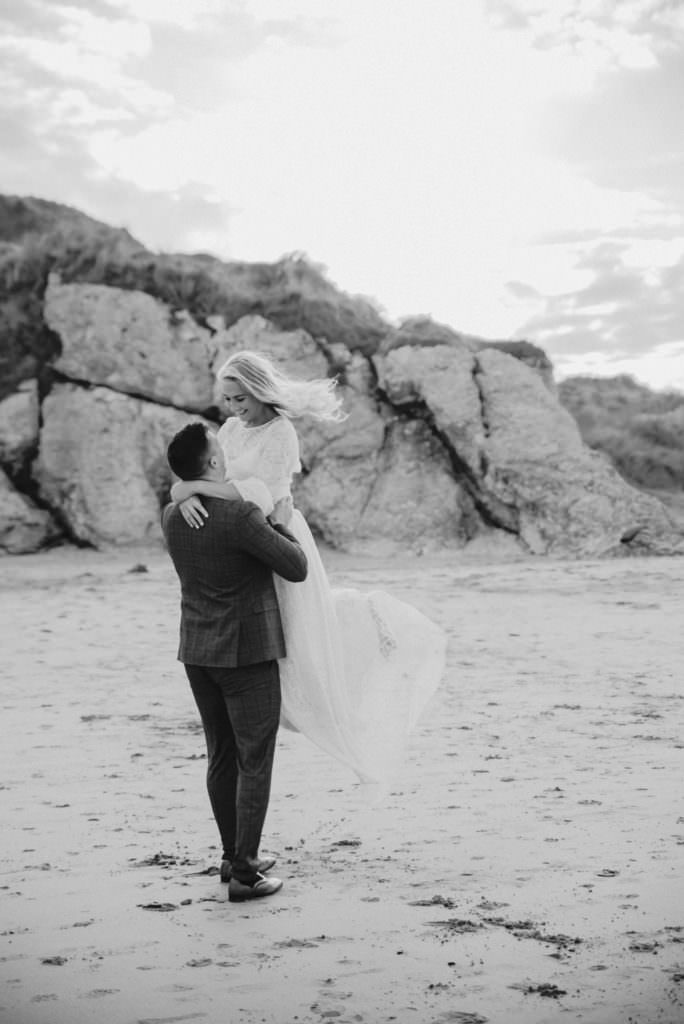 Wedding, bride, and groom walking at the beach . Wedding photographer london