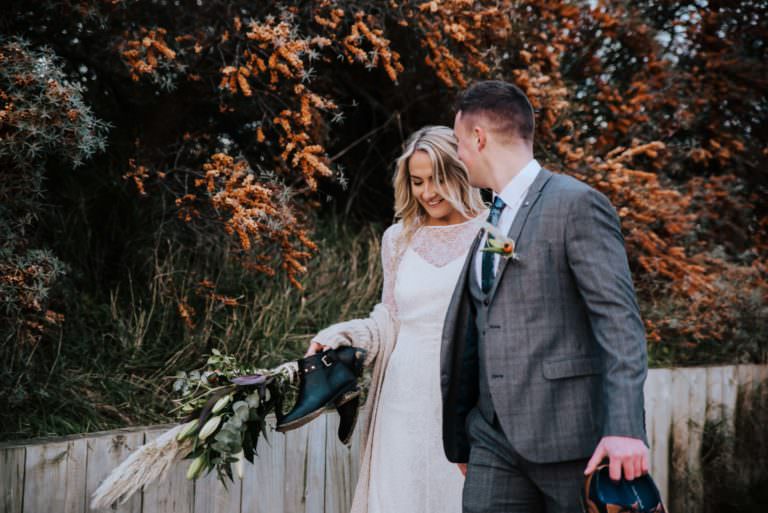 Wedding, bride, and groom walking at the beach . Wedding photographer london