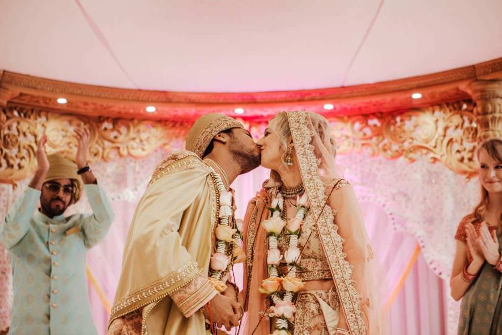 bride and groom kissing in the alter
