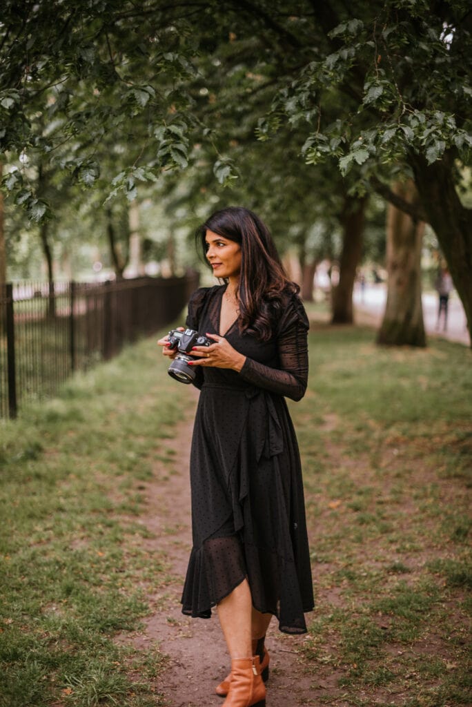London wedding photographer Headshot in a park wearing blakc dress and holding a Nikon camera